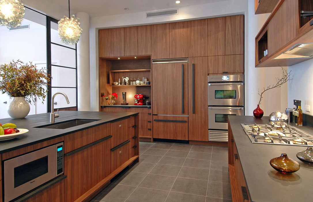 Walnut kitchen with sculptural stone island and floor-to-ceiling glass, renovated by United Elite Group
